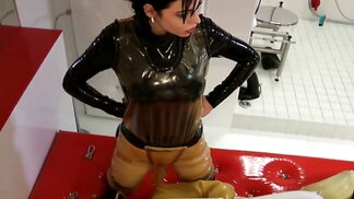 Mistress and slave are playing BDSM games in latex bondage